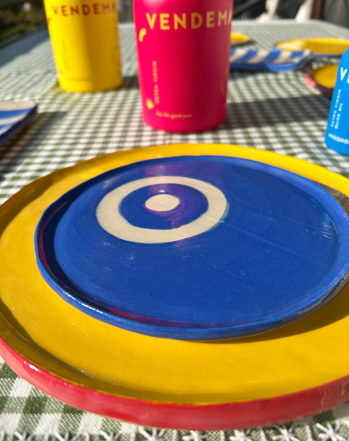 Close-ups of colourful ceramic plates and Vendema Olive Oil Bottles.