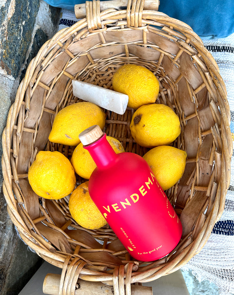 A basket with lemons and a bottle of Vendema Extra Virgin Olive Oil.