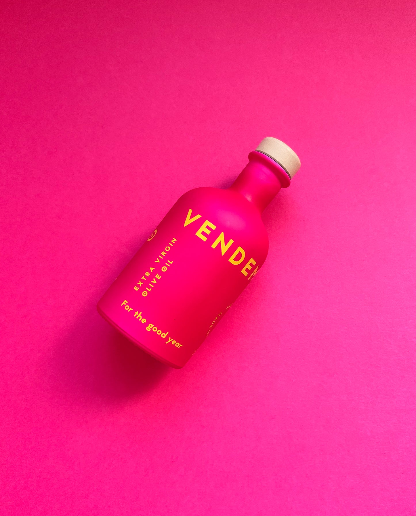 Front Side of Vendema Extra Virgin Olive Oil Small Bottle in Pink Background.