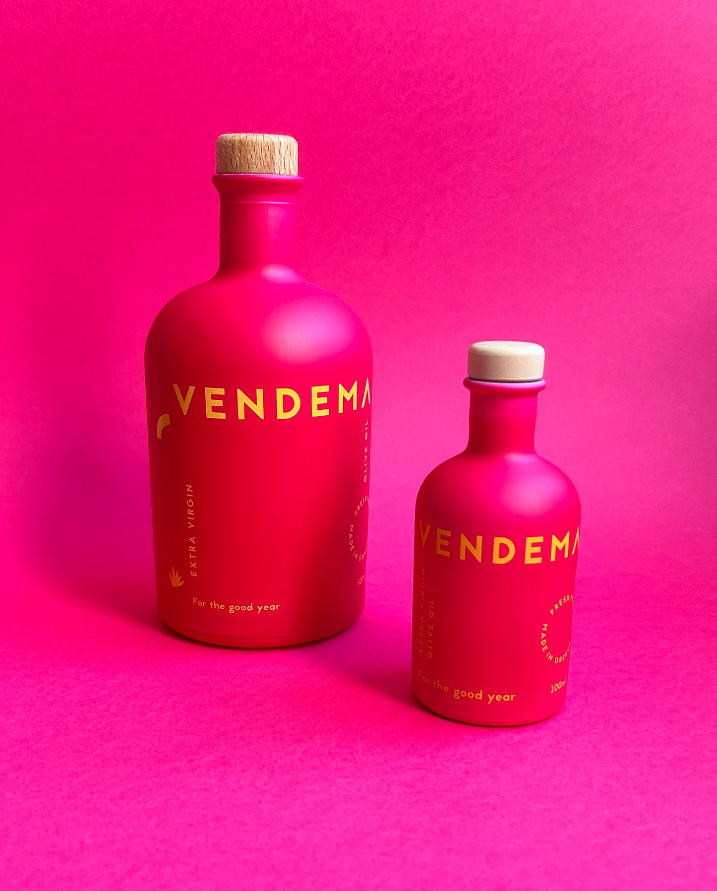 Front Side of Vendema Extra Virgin Olive Oil Bottles in Pink Background.
