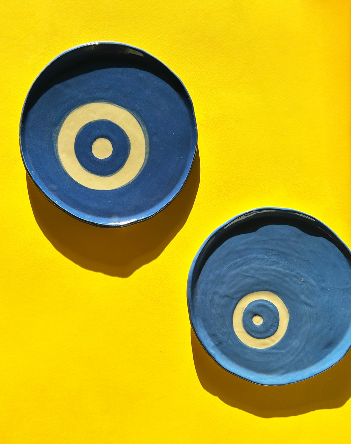 View from above of blue ceramic plates with painted evil eyes.