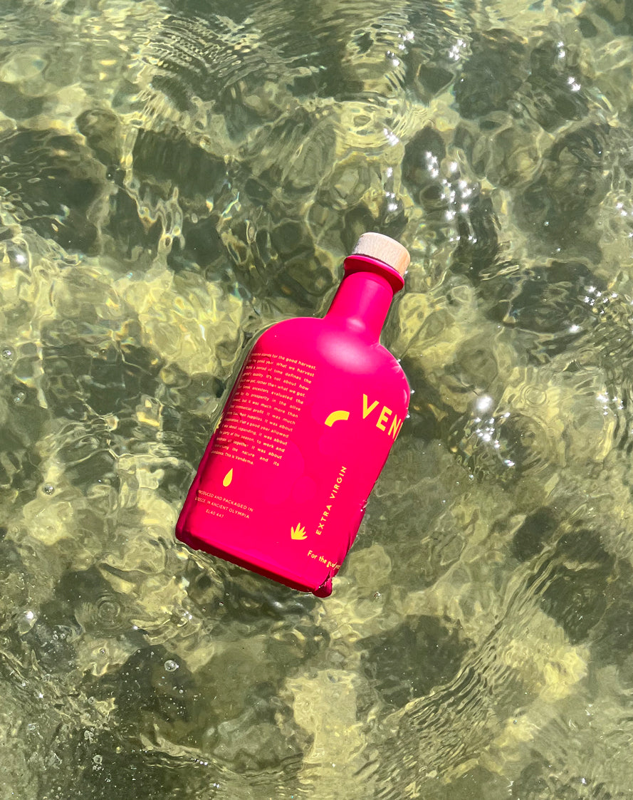 A Vendema Extra Virgin Olive Oil Bottle at the ocean.