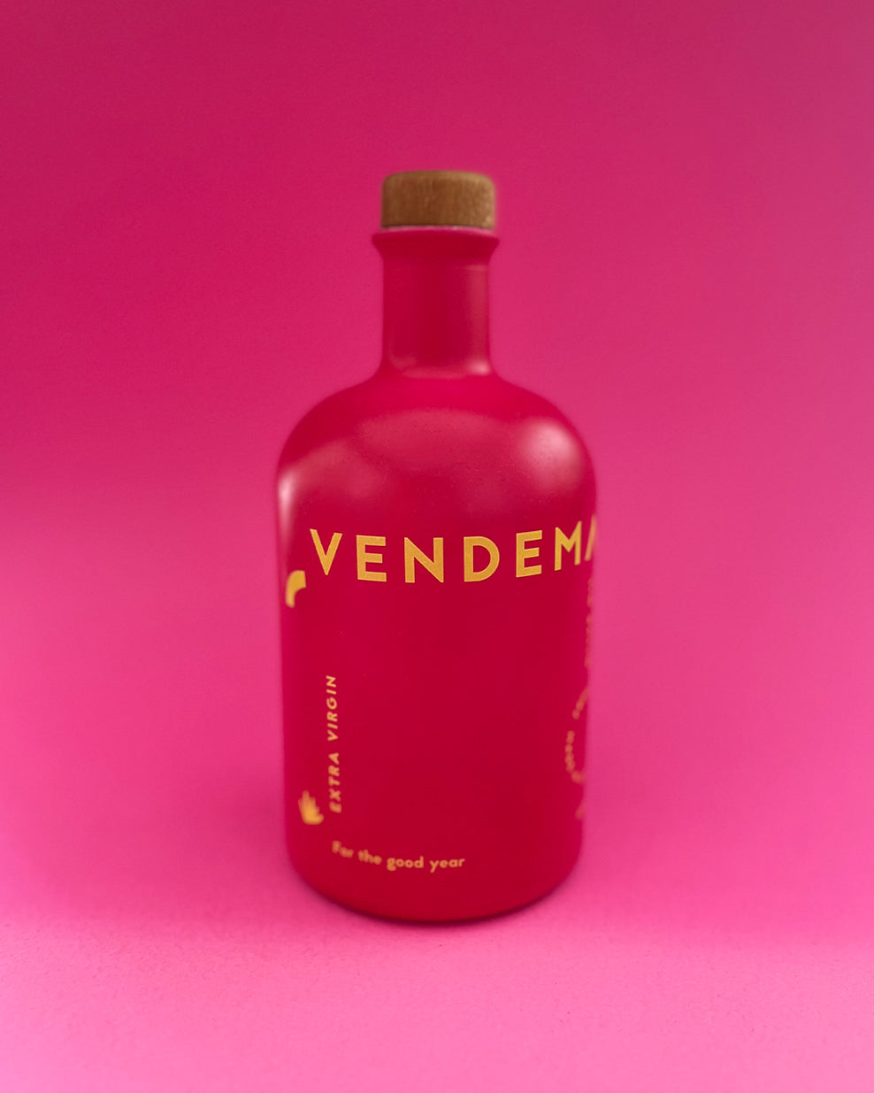 Front of Vendema Extra Virgin Olive Oil Bottle in pink background.