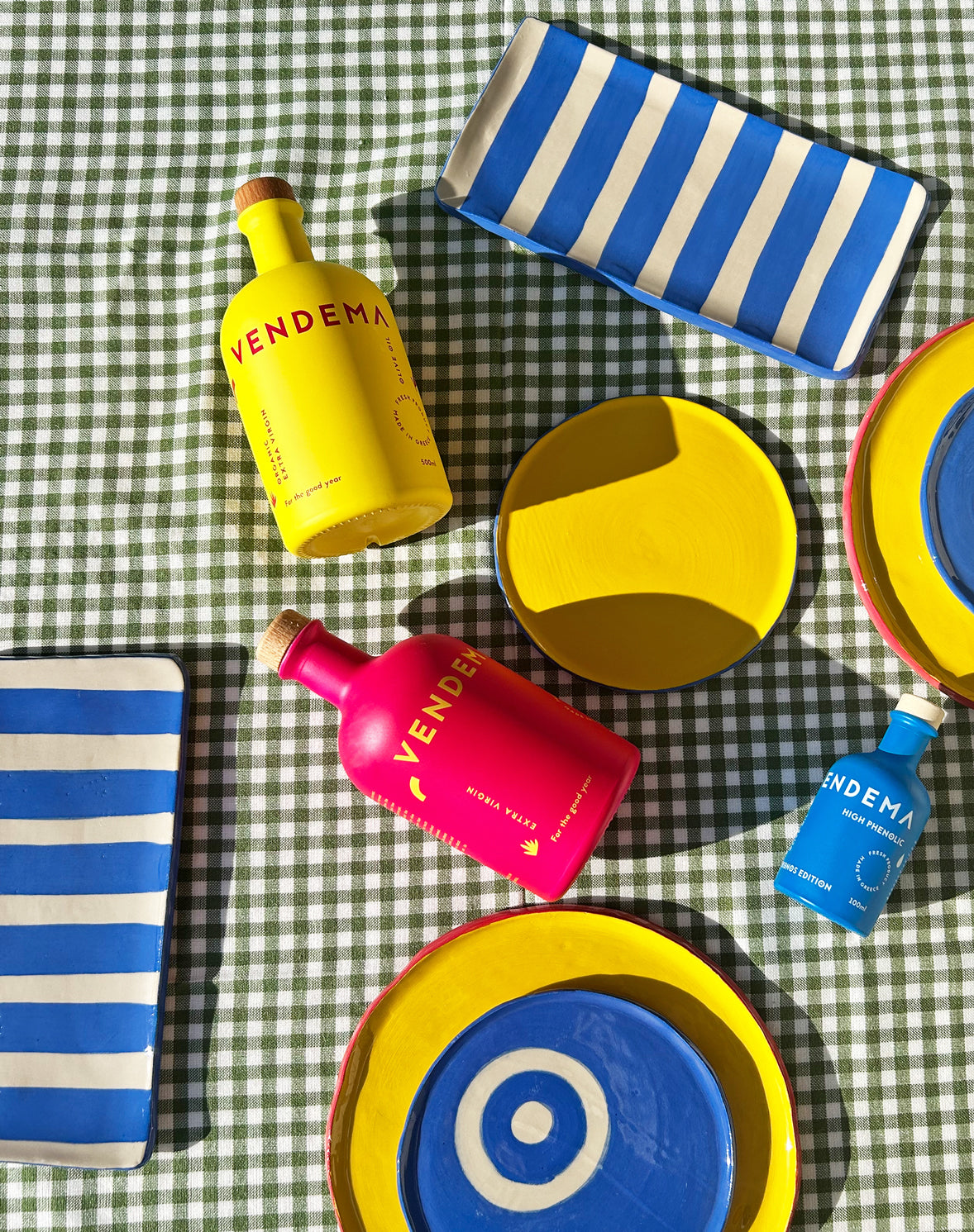 View from above of colourful ceramic plates and platters and Vendema Olive Oil Bottles.