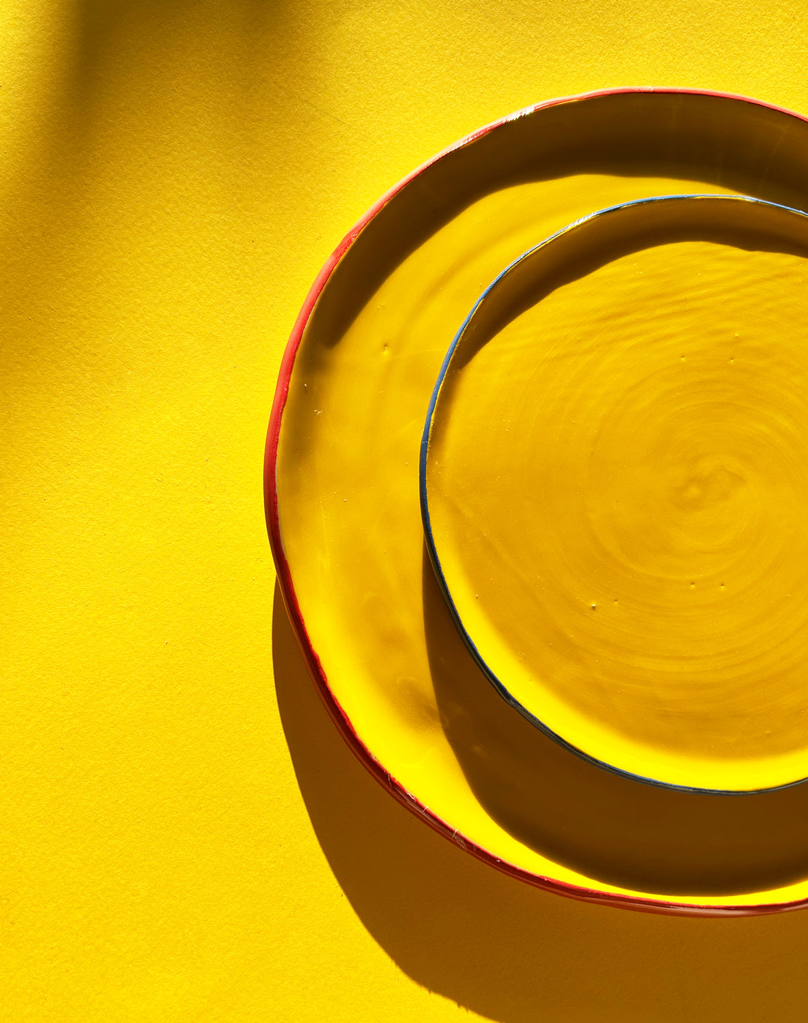 View from above of yellow ceramic dinner and salad plates.