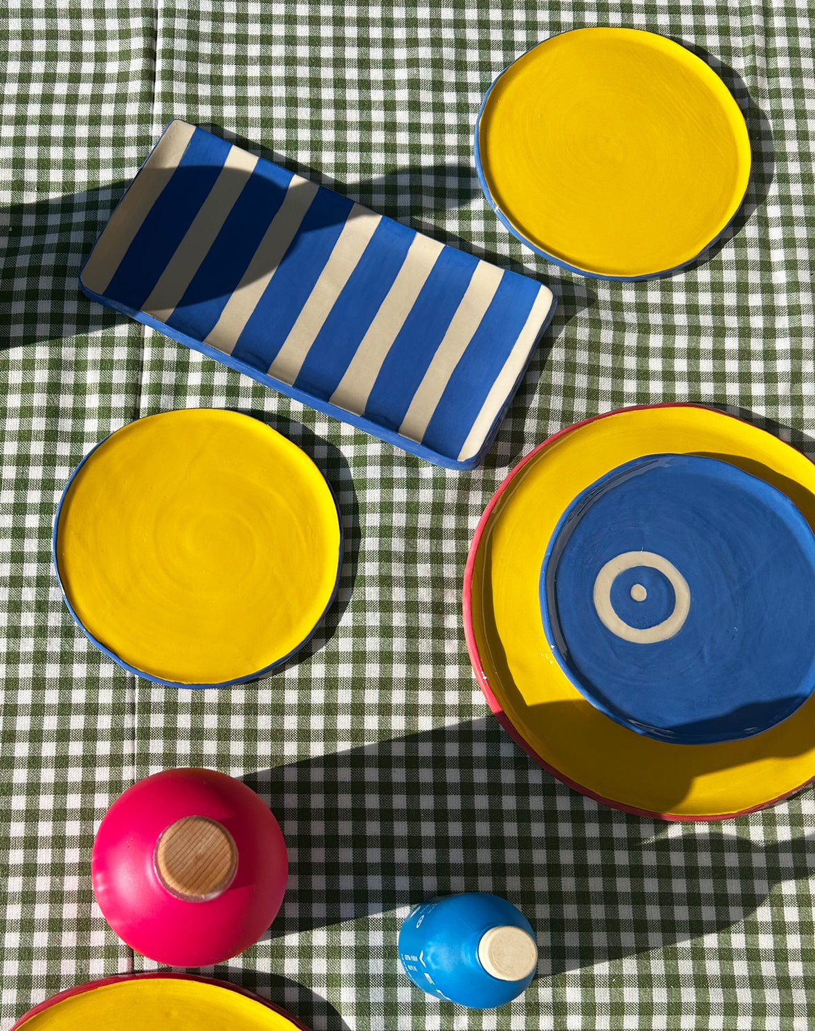 View from above of colourful ceramic plates and platters and Vendema Olive Oil Bottles.