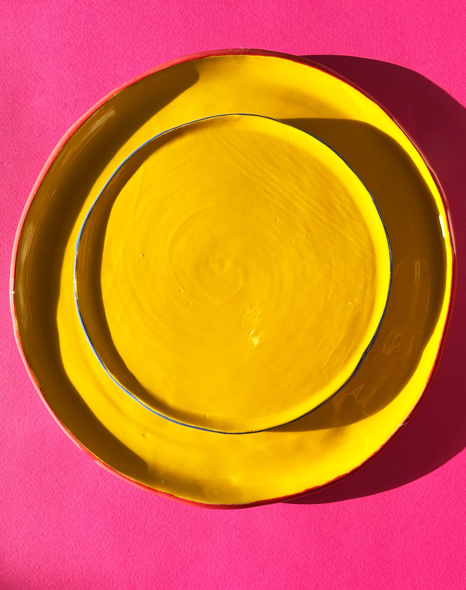 View from above of yellow ceramic dinner and salad plates.